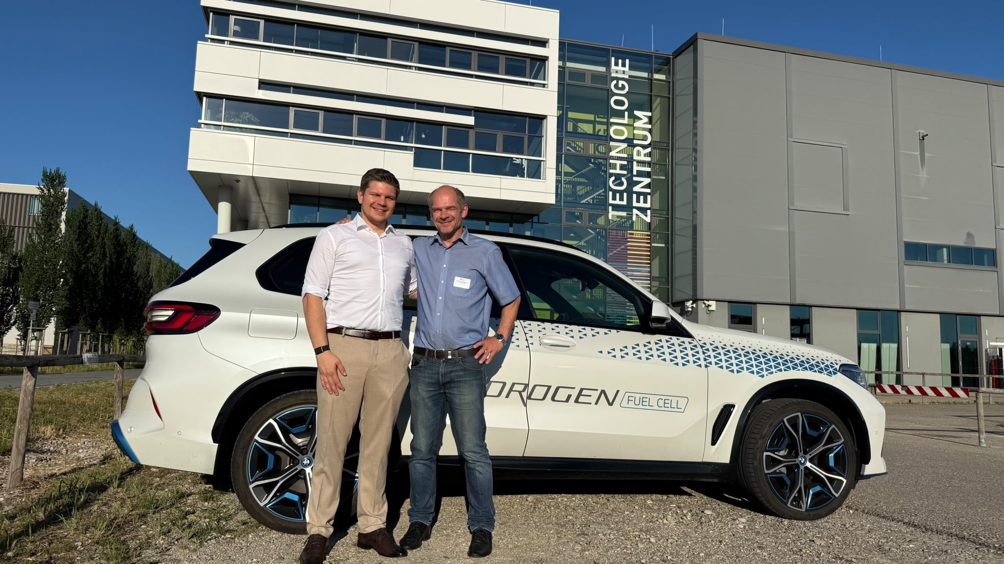 Alexander Kümmelschuh and Prof. Dr. Richard Weihrich in front of a BMW iX5 Hydrogen at the Augsburg Technology Center